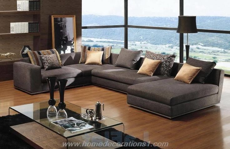 a living room filled with lots of furniture next to a large window overlooking a valley