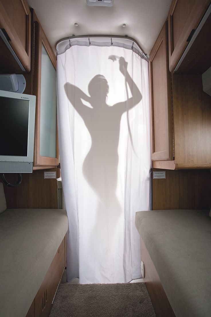 the shadow of a woman holding a tennis racquet in front of a window