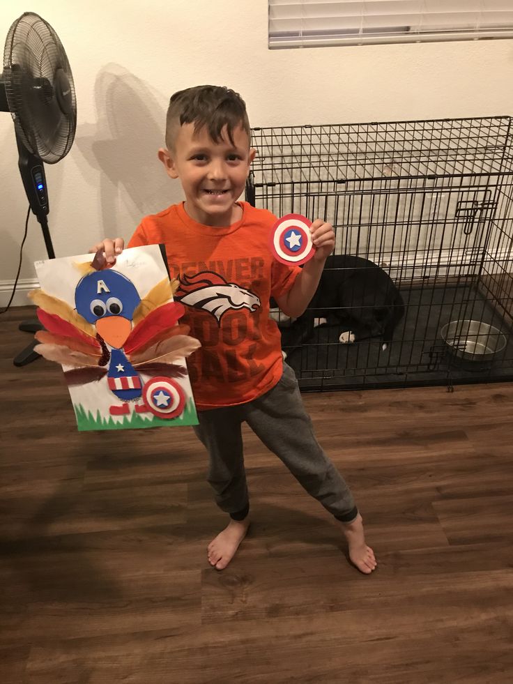 a young boy is holding up some kites in his hand and smiling at the camera