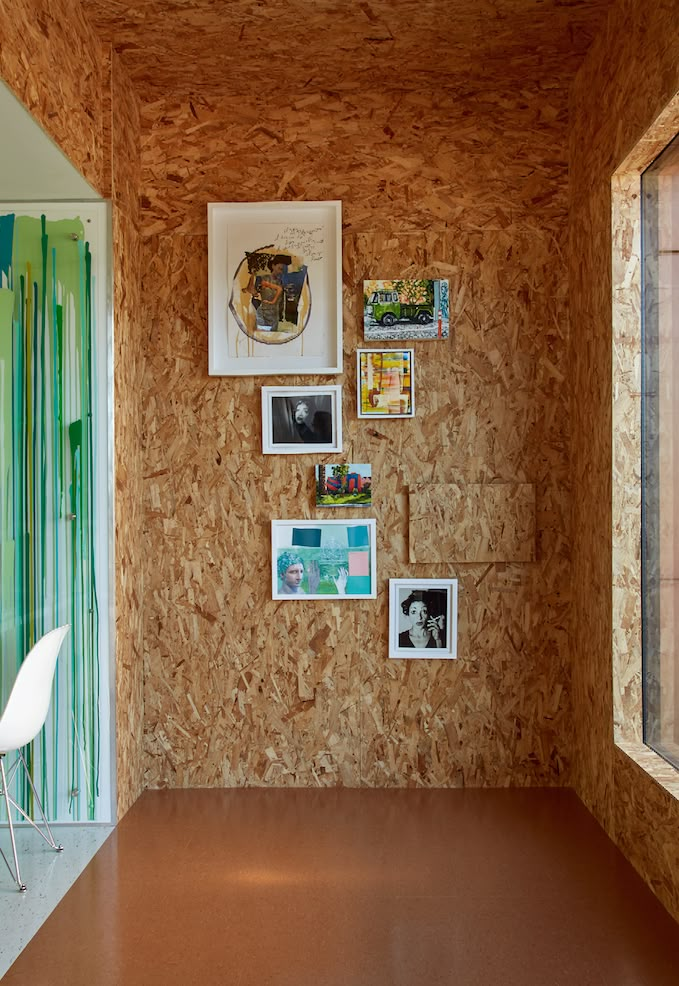 a room with wood paneling and pictures on the wall next to a white chair