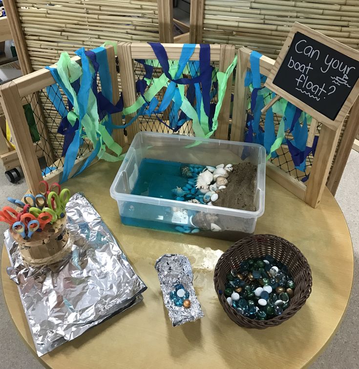 a table topped with lots of crafting supplies on top of a wooden table covered in tin foil