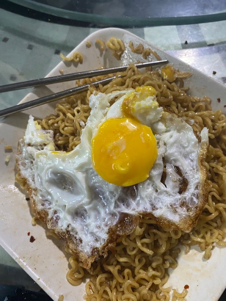 a plate with noodles and an egg on top