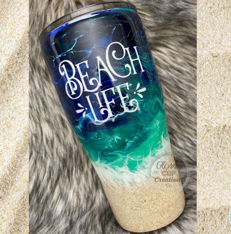 the beach life tumbler is next to an image of sand and blue water on it