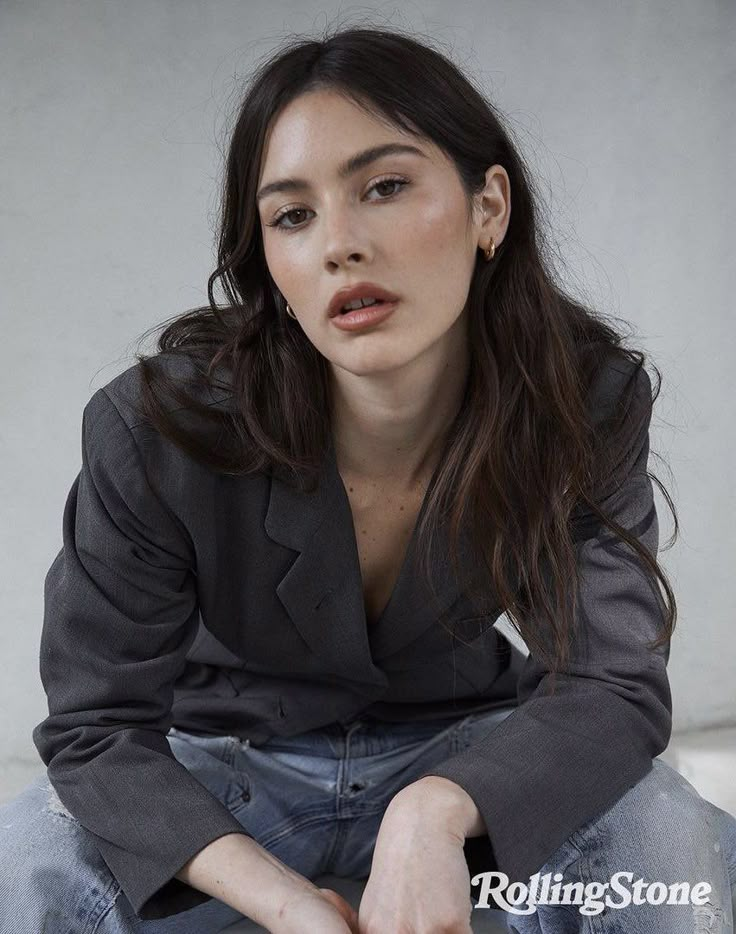 a woman sitting on the ground with her hands crossed