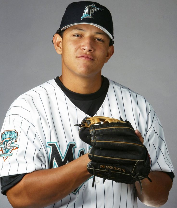 a baseball player is posing for a photo with his mitt in front of him