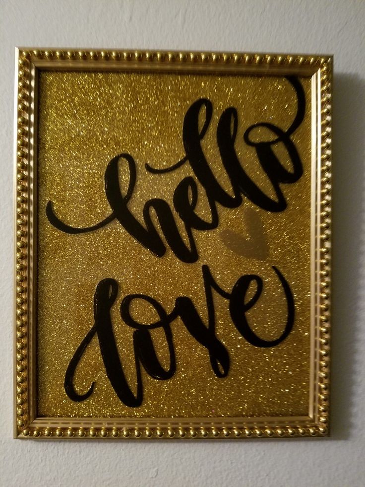 a gold framed sign with the words hello love written in cursive black ink