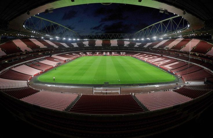 an empty soccer stadium at night with the lights on