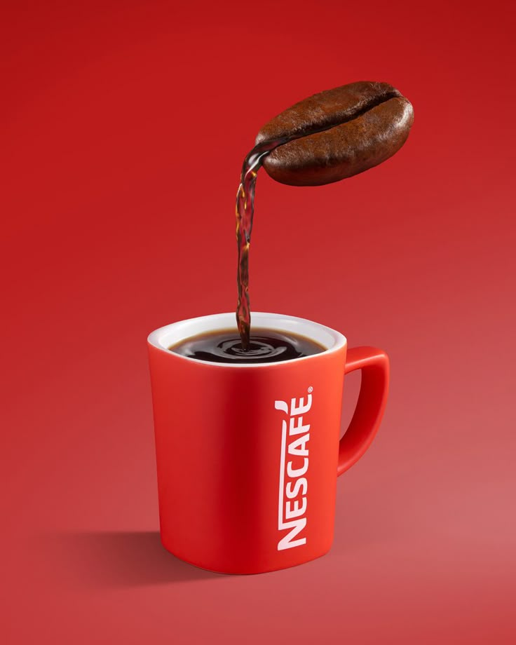 a cup of coffee being poured into it with a hot beverage in the middle, on a red background