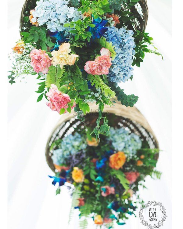 colorful flowers hanging from the ceiling in a basket