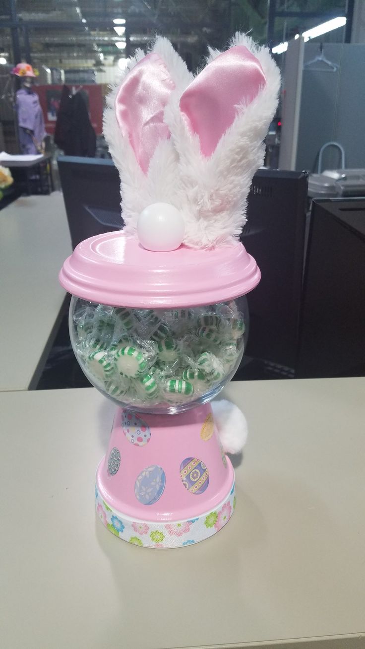 a pink candy machine with bunny ears on it's top and gummy balls in the bottom