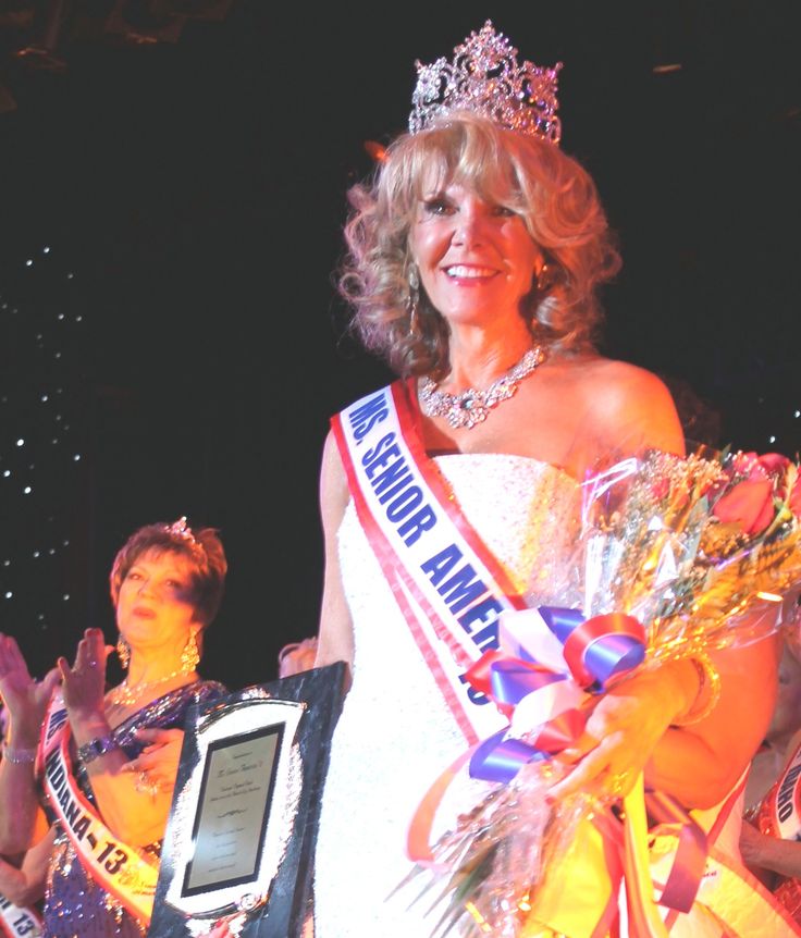 a woman wearing a tiara and holding an award