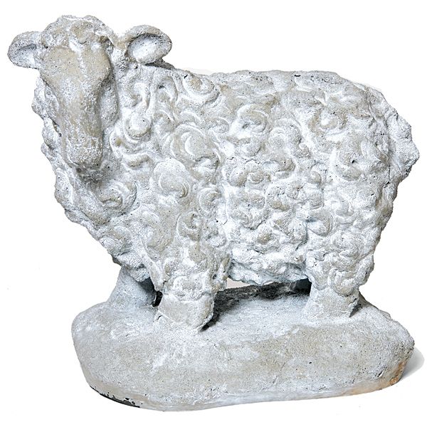 a white sheep statue sitting on top of a stone slab with swirly curls in it's fur