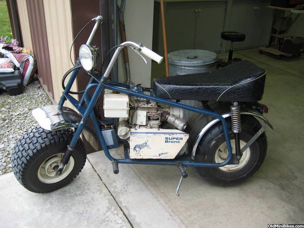 a small blue motorcycle parked in front of a garage