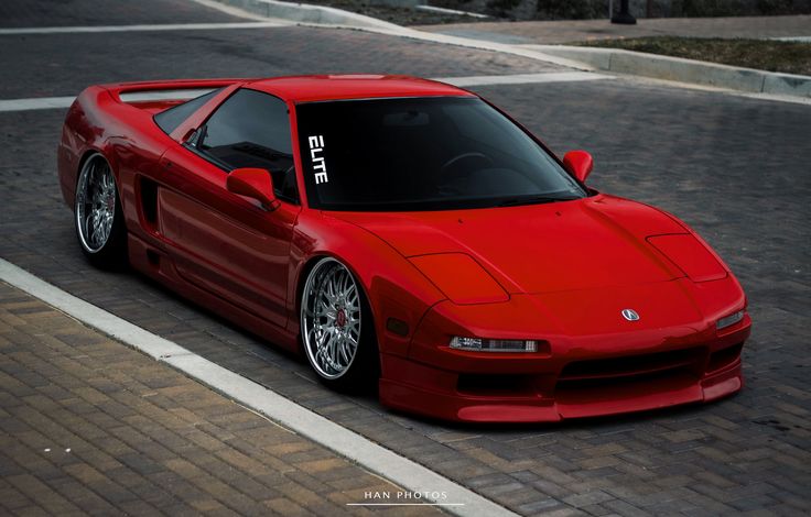 a red sports car is parked on the street