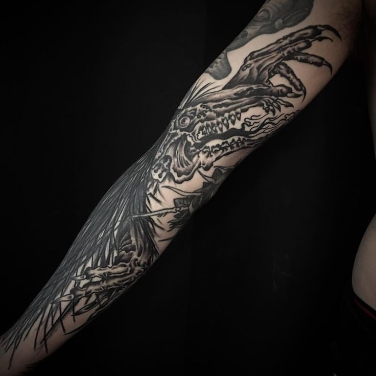 a man's arm with a dragon tattoo on it