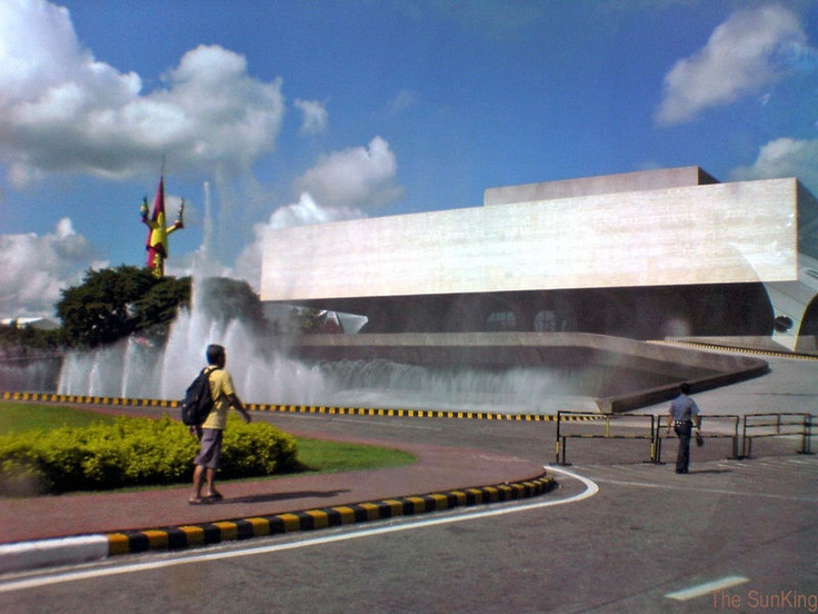 a man standing in front of a fountain with water shooting out of it's sides