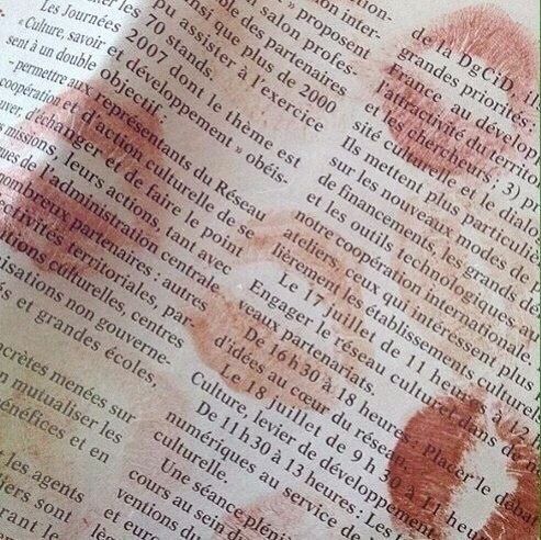 a close up of a book with some writing on the pages and an image of a person's hand