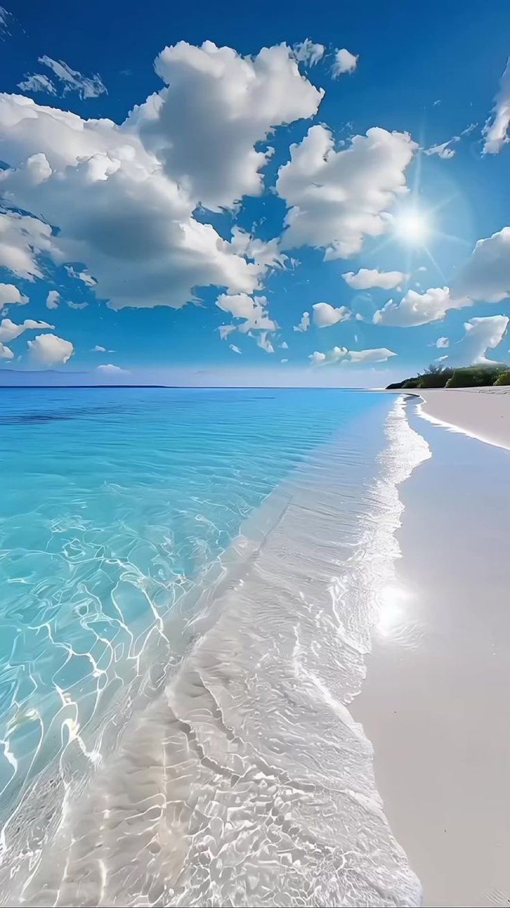 the beach is clear and blue with white clouds in the sky above it, as well as water below