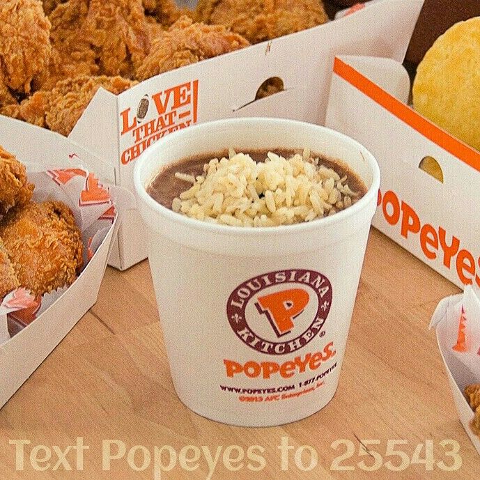 chicken nuggets, rice and soup in paper cups on a table with other food items