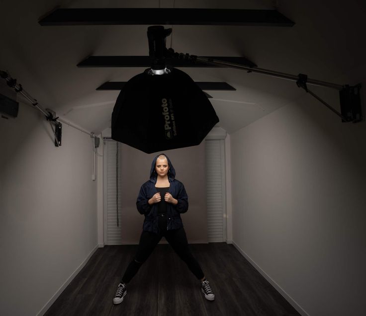 a woman is standing in the middle of an empty room, holding her hands together