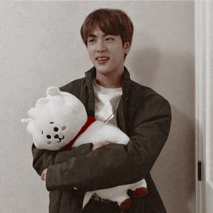 a man holding a white teddy bear in his arms