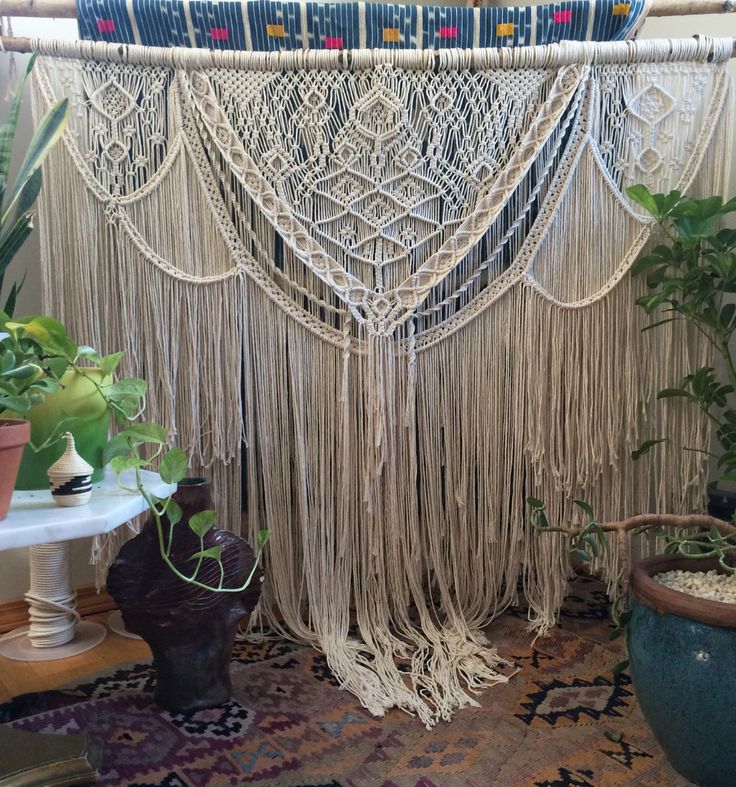 a large macrame hanging from the ceiling in a room with potted plants