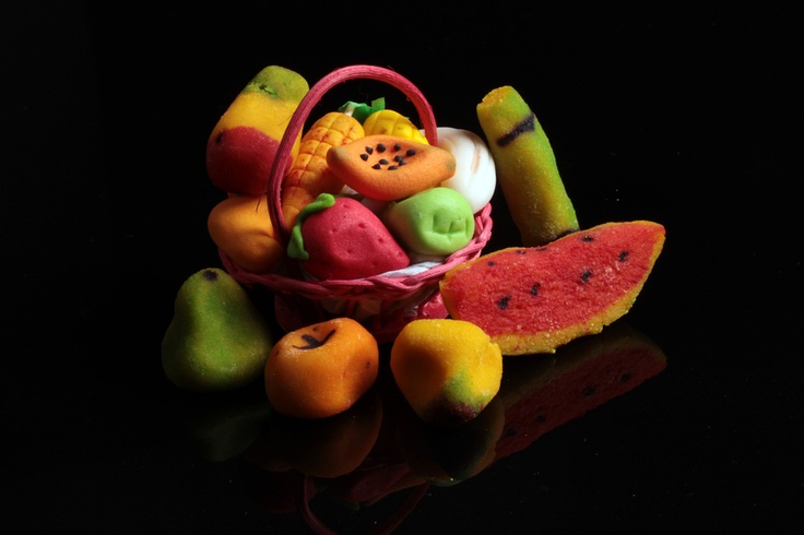 a basket filled with fruit sitting on top of a black table next to watermelon