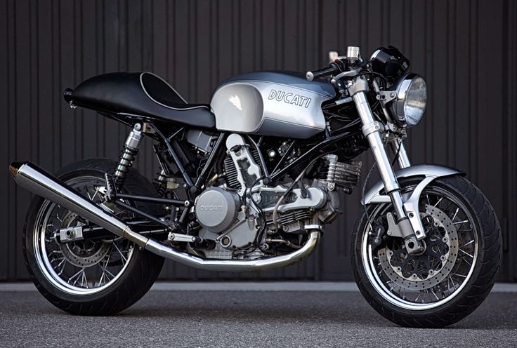 a silver and black motorcycle parked in front of a building