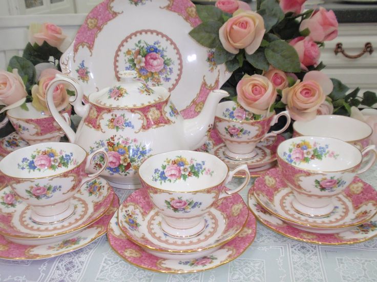 a table topped with pink roses and china