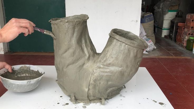 someone is making a vase out of clay