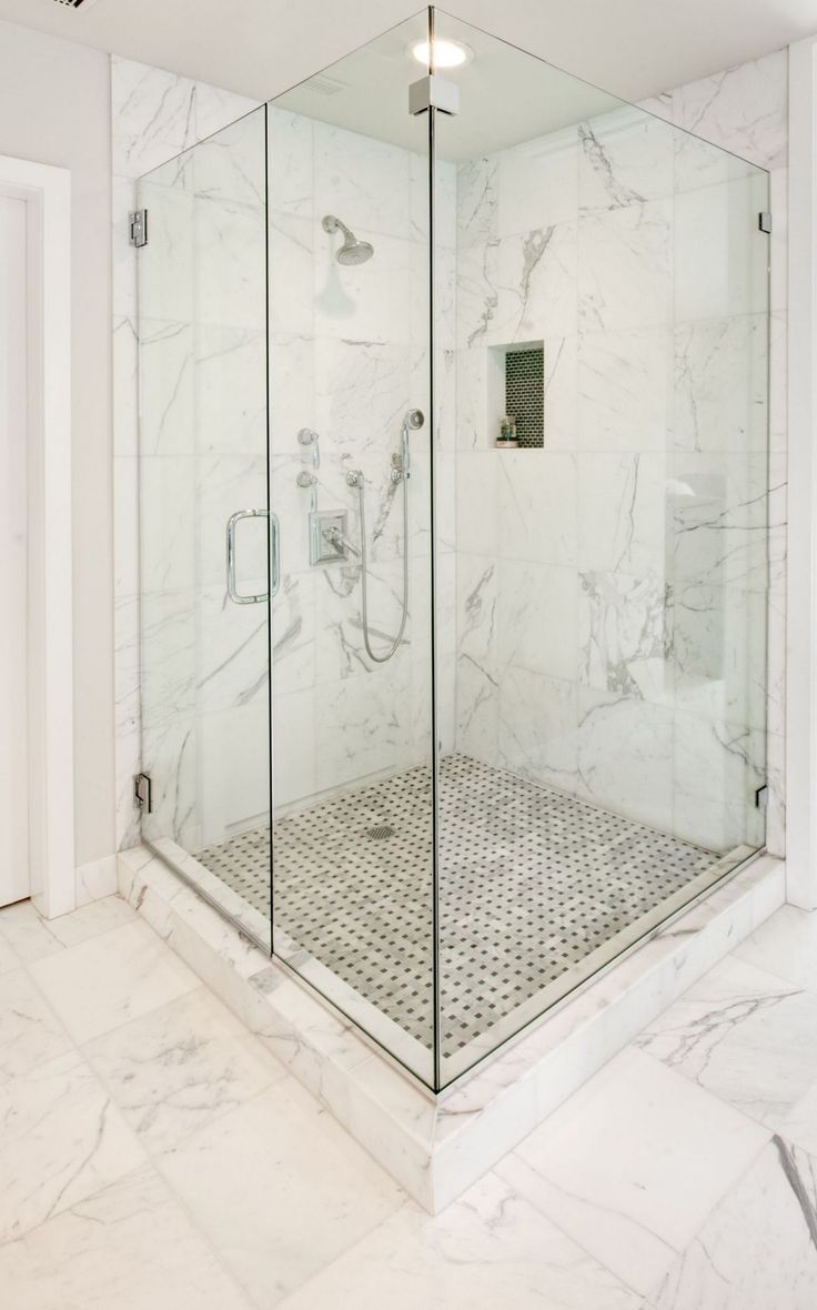 a walk in shower sitting inside of a bathroom next to a white wall and floor