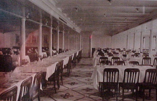 an old photo of a dining room with tables and chairs set up for formal function