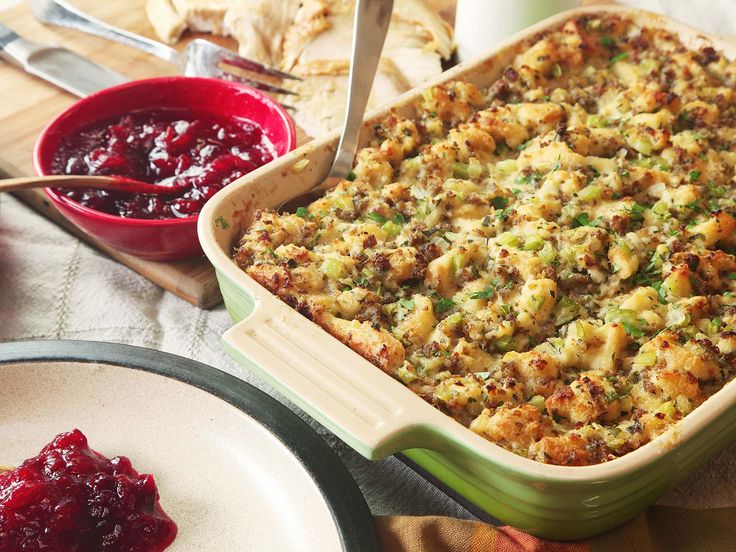 a casserole dish with stuffing and cranberry sauce next to breadcrumbs