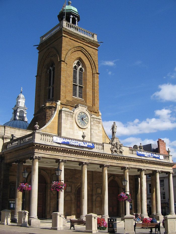 an old building with columns and a clock on the front, against a blue sky