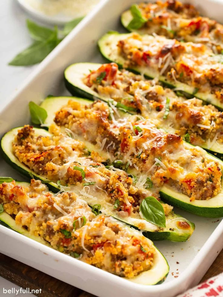 stuffed zucchini boats with meat and cheese in a white casserole dish