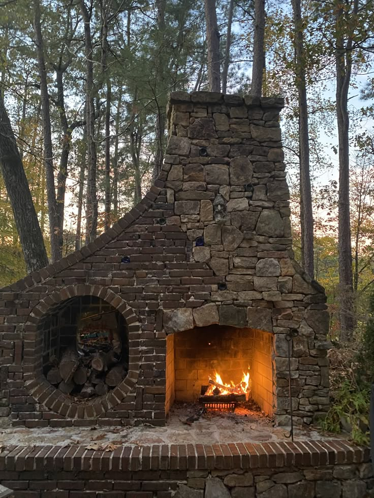 an outdoor brick fireplace in the woods