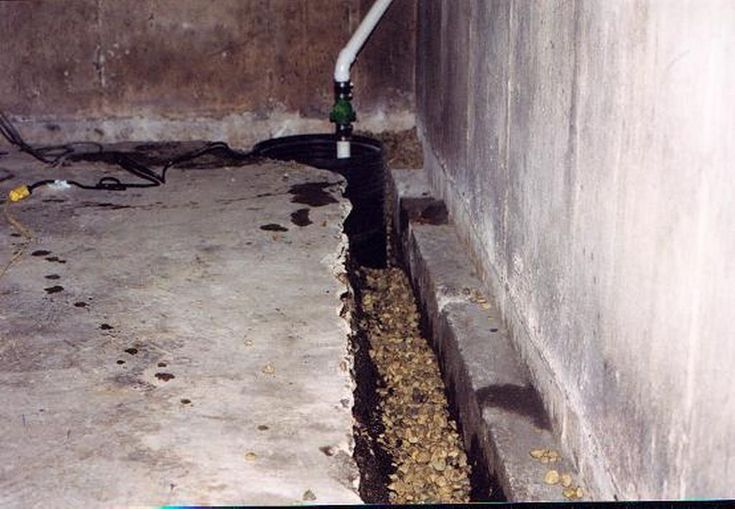 a pipe is connected to the ground in an unfinished room with concrete walls and flooring