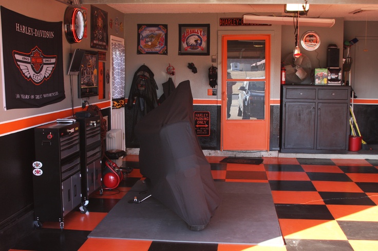 an orange and black checkered floor in a garage with a motorcycle cover on it