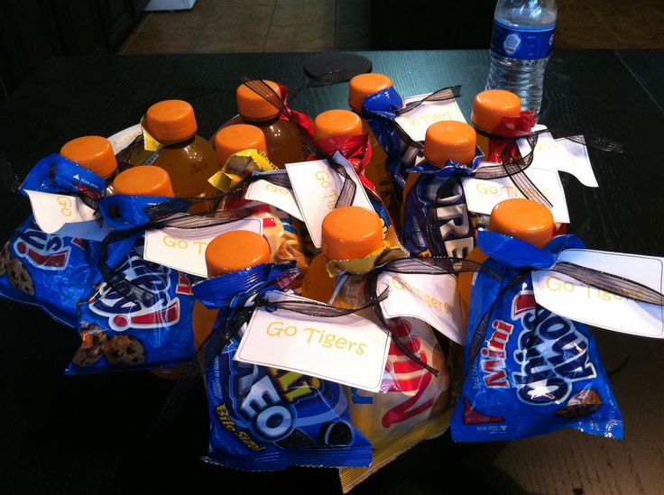 a bunch of soda bottles sitting on top of a table next to bags of chips