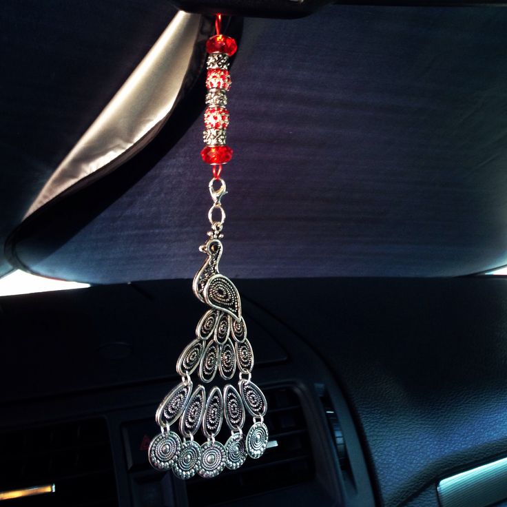 a car dashboard with a red beaded necklace hanging from it's center console