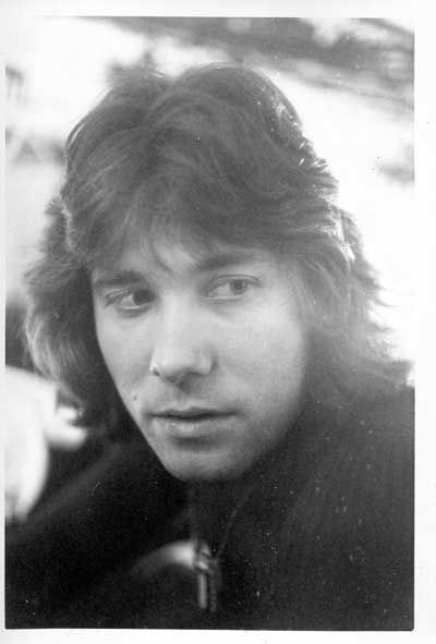 an old black and white photo of a man with long hair looking at the camera