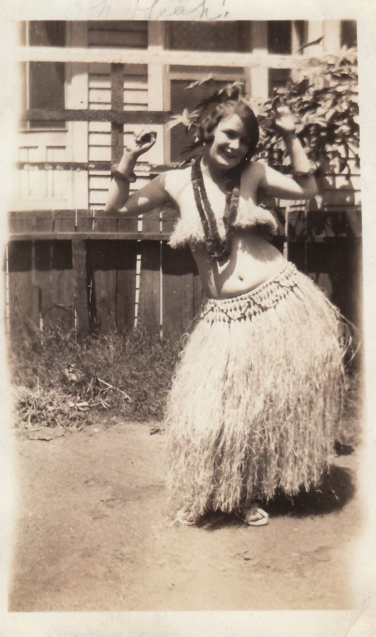 an old black and white photo of a woman in a hula skirt