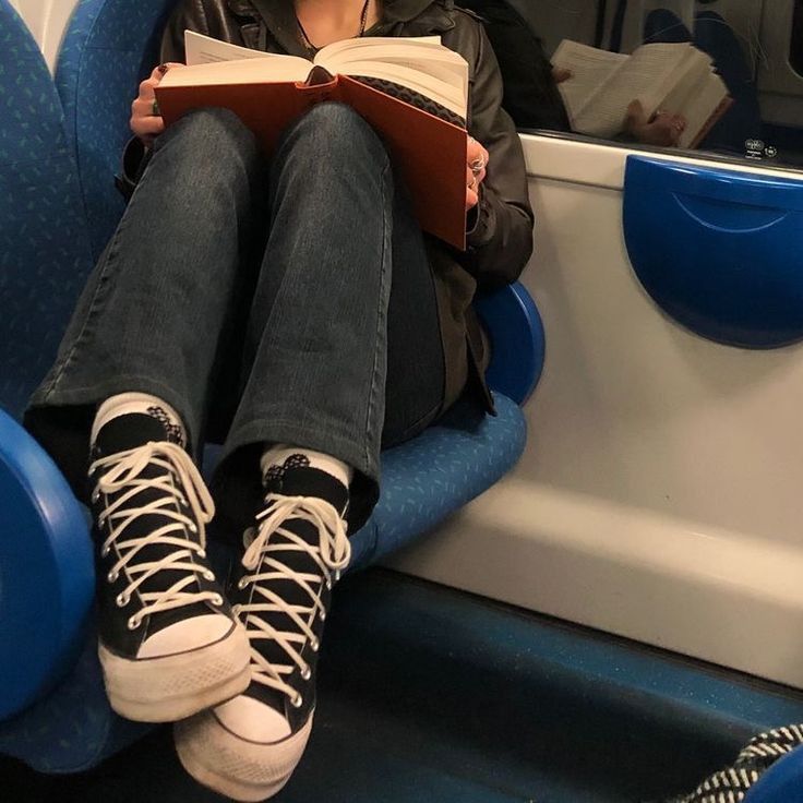 a person sitting on a bus reading a book