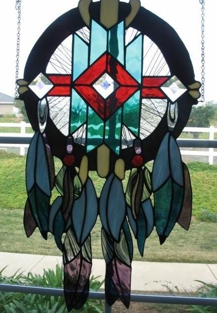 a stained glass dream catcher sitting on top of a window sill