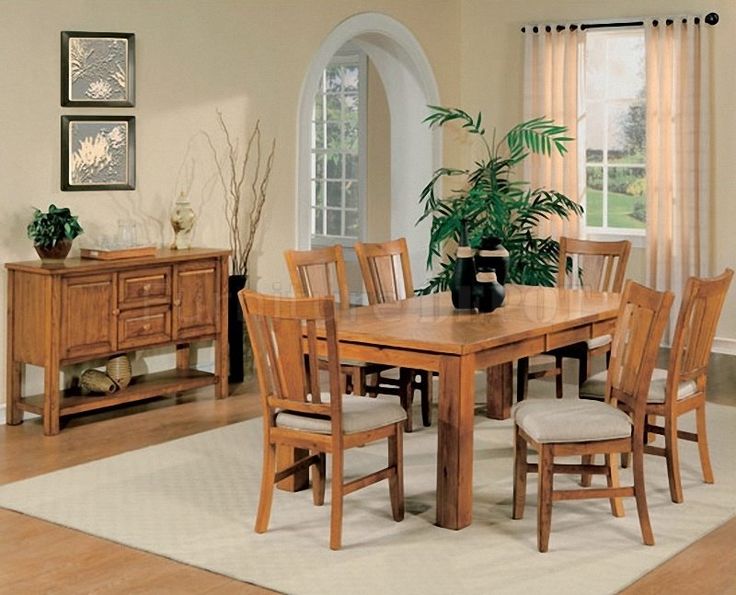 a dining room table with chairs and a potted plant