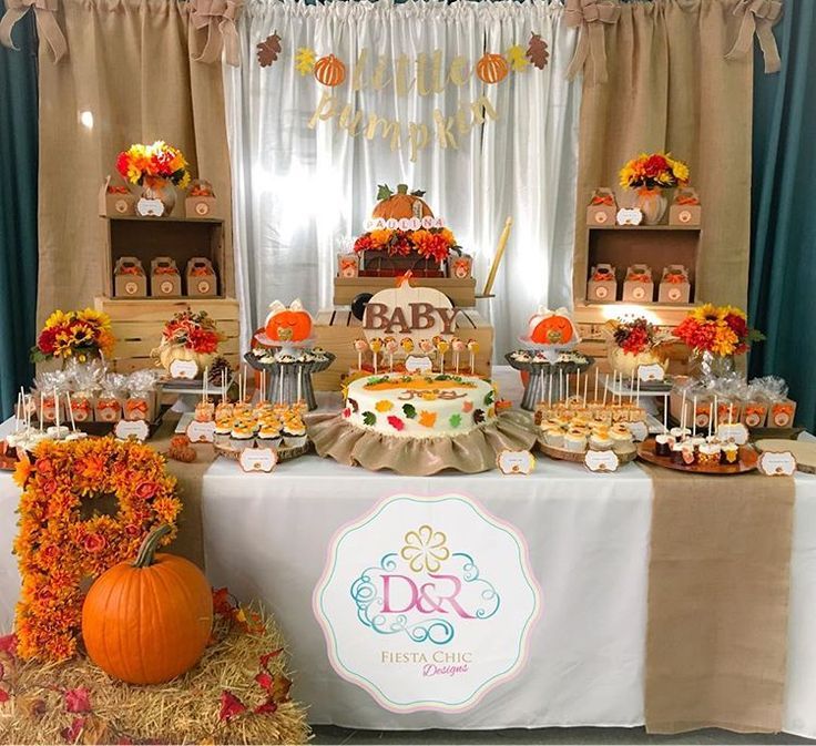 a baby shower party with pumpkins and cupcakes