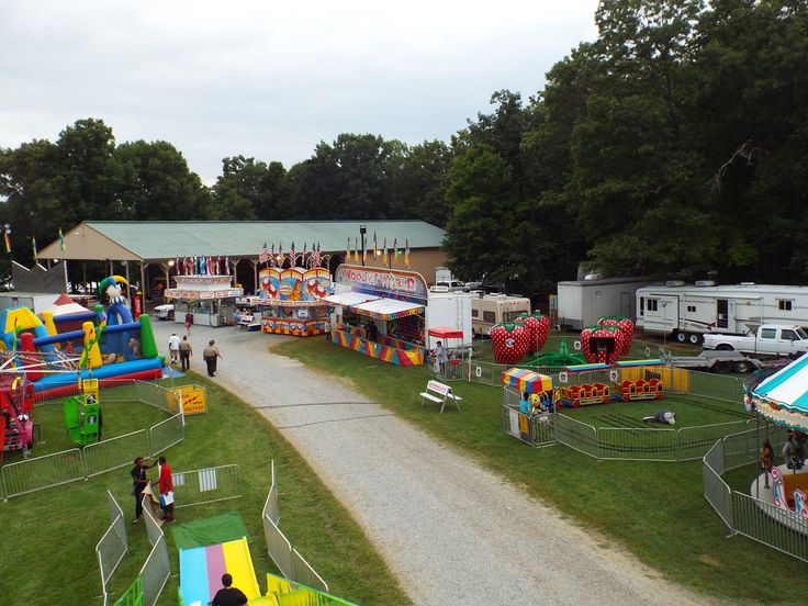 several carnival rides and games are set up on the grass