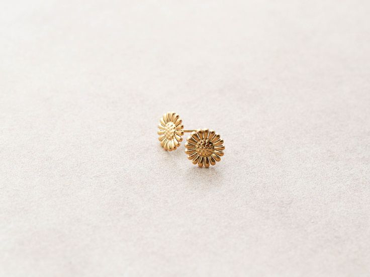 Our Sunflower earrings come in either silver or gold and make the best compliment to our new Daisy Chain. Made with 14k gold over stainless steel makes these both hypoallergenic and waterproof. Earrings are packaged into our Tom Design logo stamped boxes, perfect for gift giving. Measures about 10mm in diameter. Yellow Gold Birth Flower Earrings Gift, Gift Gold Flower Earrings Tarnish Resistant, Gold Tarnish-resistant Flower Earrings Perfect For Gifts, Gold Tarnish-resistant Flower Earrings For Gift, Hypoallergenic 14k Gold Flower-shaped Jewelry, Yellow Gold Stainless Steel Earrings For Gift, Flower Shaped Tarnish Resistant Earrings For Gift, 14k Gold Filled Flower Earrings As Gift, Gold Sunflower Adjustable Flower Earrings