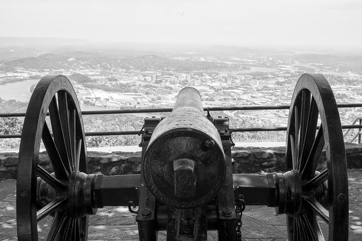 an old cannon on top of a hill overlooking a city