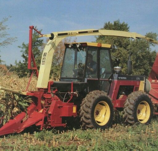 a tractor is parked in the middle of a field with corn on it's back